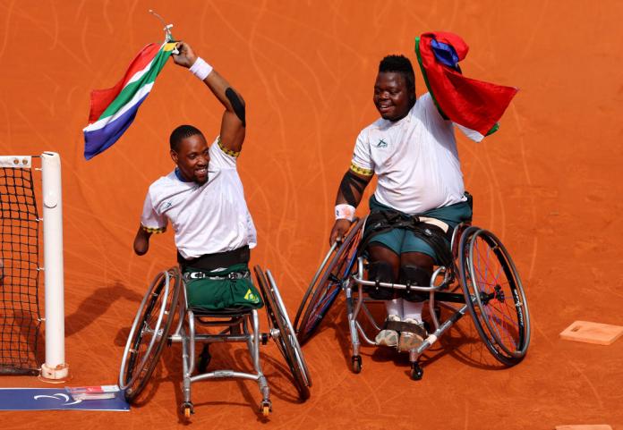 Donald Ramphadi and Lucas Sithole wave South African flags on court