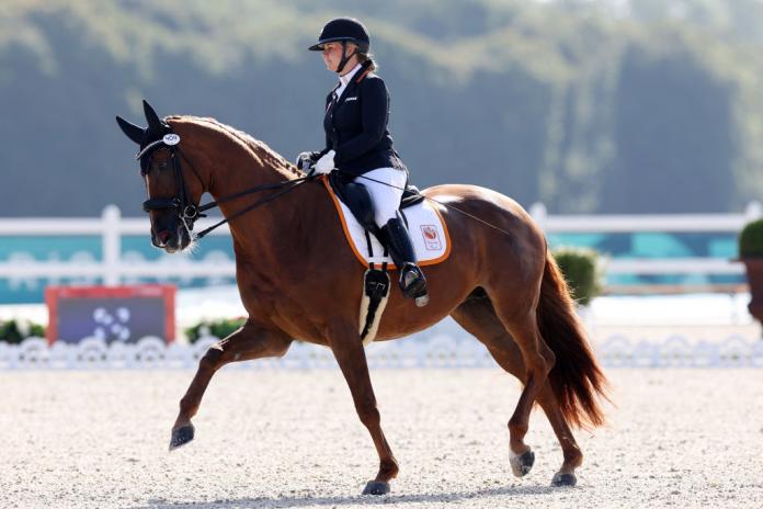 A woman rides a horse in a Para equestrian competition