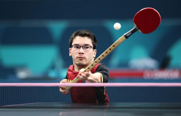 Ian Seidenfeld, del equipo de Estados Unidos, devuelve una pelota de tenis de mesa con una paleta que está unida a un palo
