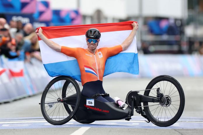 Para cyclist Mitch Valize holds up the Netherlands flag