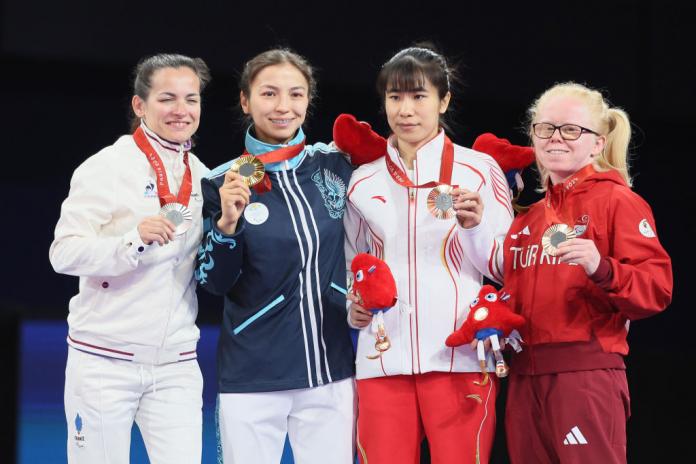 Four female Para judokas with their medals on the podium 
