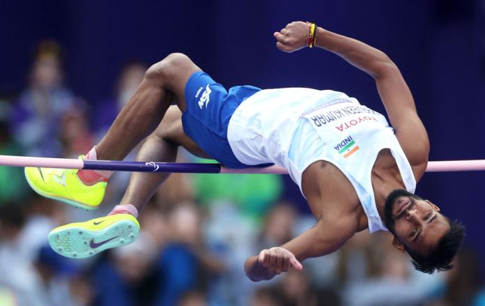Man jumps over high jump pole in india kit