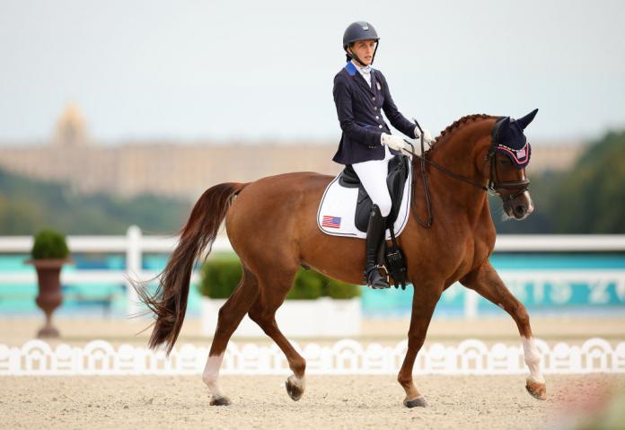 A woman rides a horse in a Para equestrian competition