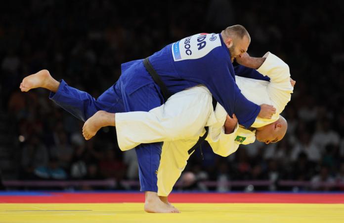 Two men compete in Para judo, one in white and one in blue