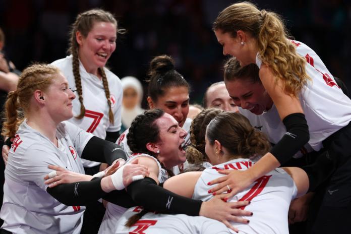 El equipo femenino de voleibol sentado de Canadá se abraza y anima en celebración