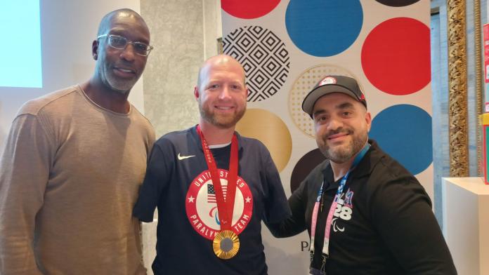 man in centre with medal with two men wither side