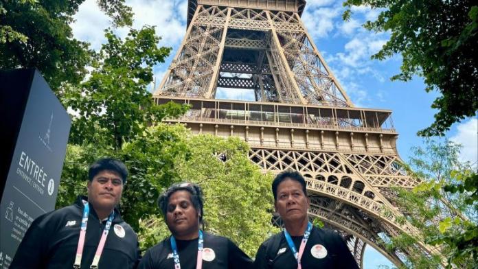 Para athlete Ongiou Timeon with two team members at the Eiffel Tower