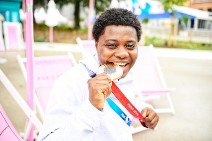 Mariam Eniola Bolaji bites her medal 