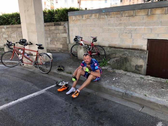 Martin Heggelund sitting on the side of the road drinking water