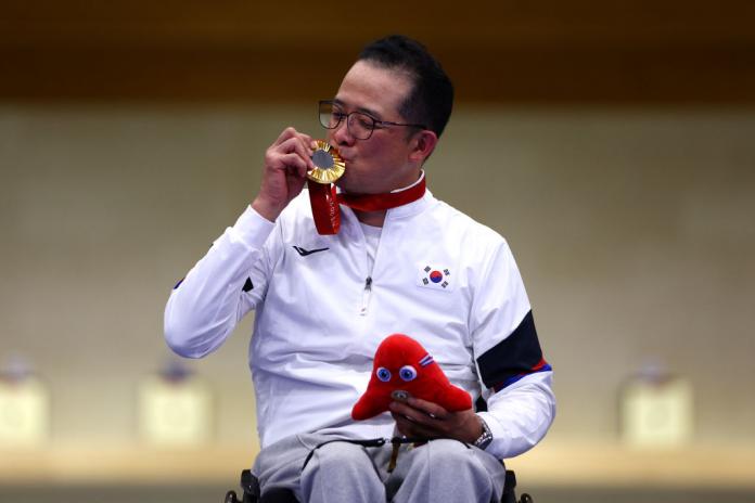 Un atleta besando una medalla de oro