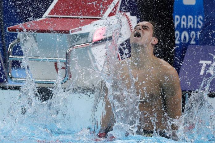 Ugo Didier splashes the water in the pool in celebration