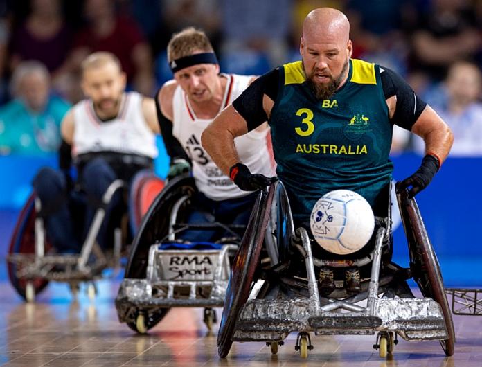 Ryley Batt, un atleta de rugby en silla de ruedas, lleva una pelota durante la competencia.