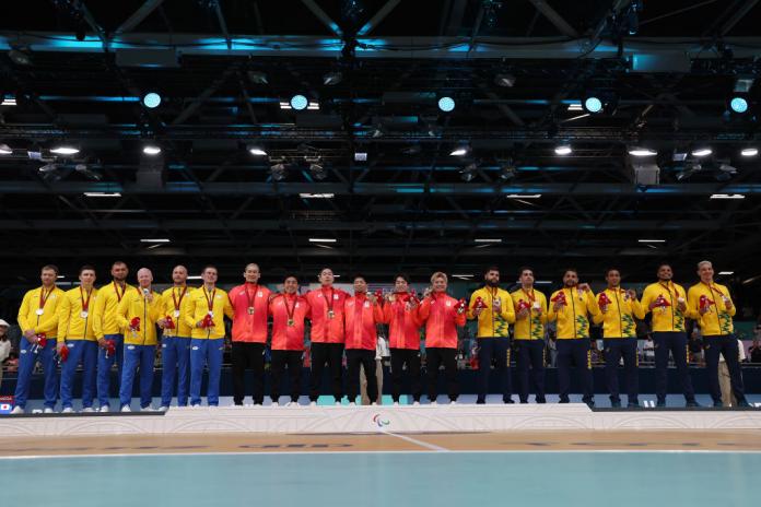 Players from three goalball teams (Ukraine, Japan and Brazil) pose for a photograph on the podium 