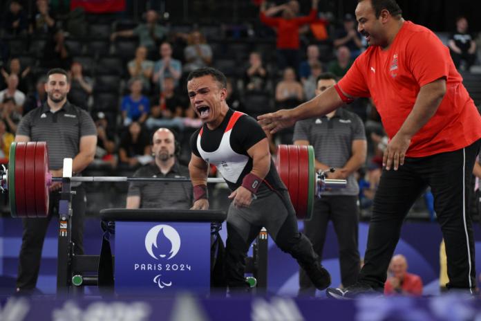 A male Para powerlifting athlete reacts after his lift