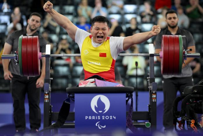 A male Para powerlifting athlete reacts after his lift