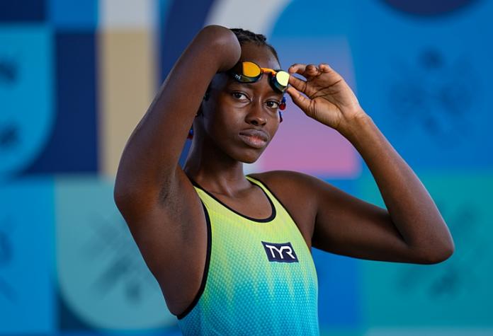 Husnah Kukudakwe, una atleta de Uganda, posa para una foto con su traje de baño amarillo y azul.