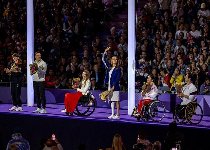Five athletes are on the stage at the Paris 2024 Paralympic Games Closing Ceremony.