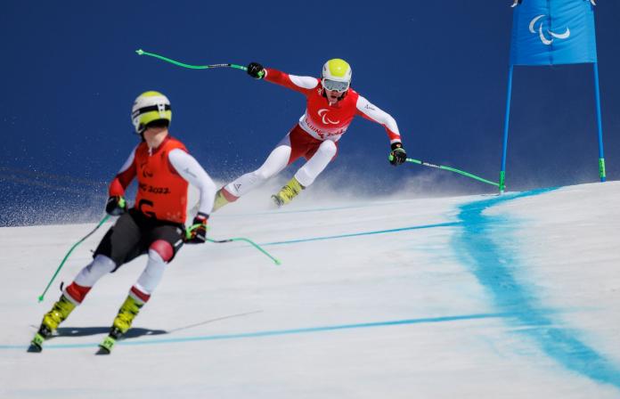 A male alpine skier follows his guide skier during competition