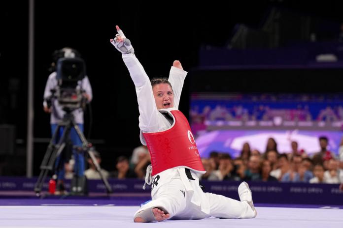 Amy Truesdale, atleta femenina de Para taekwondo, celebra en el tatami tras ganar una medalla