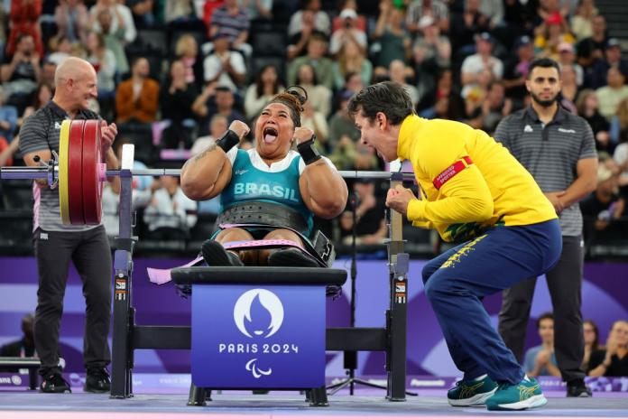 Tayana Medeiros pumps her fist after a successful lift