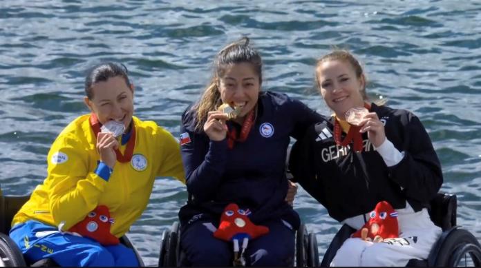 Three female athletes pose for a photo on the podium