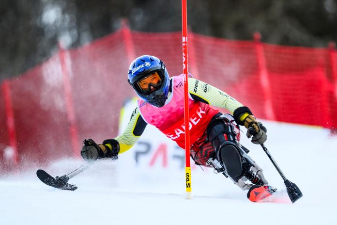 A female Para alpine sit skier is in action
