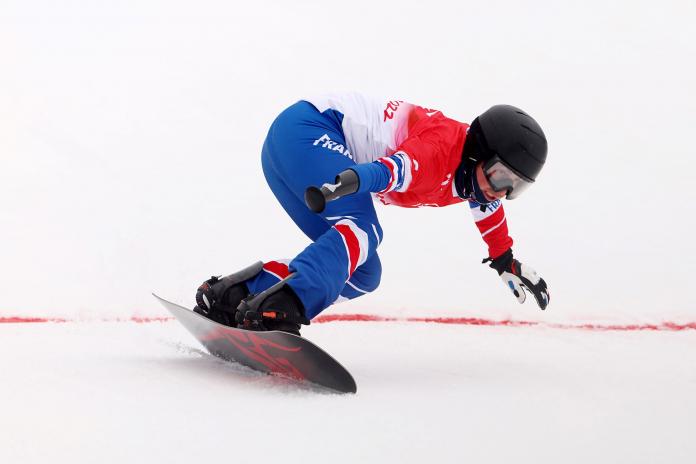 A male Para snowboard athlete competes at the Beijing 2022 Paralympic Winter Games