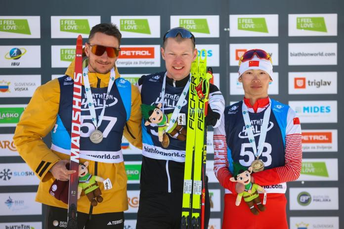 Three male athletes are posing for a picture on the podium