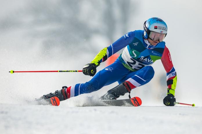 A male Para alpine skiing athlete is competing