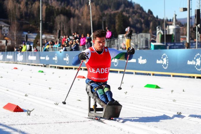 A male athlete is competing on a sit-ski
