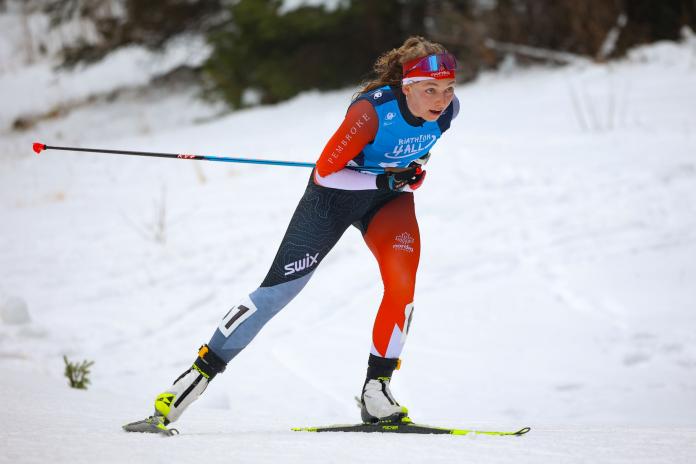 A female Para biathlon athlete is skiing in the standing category