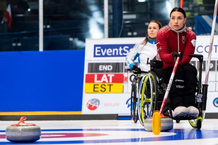 A female wheelchair curling athlete in competition