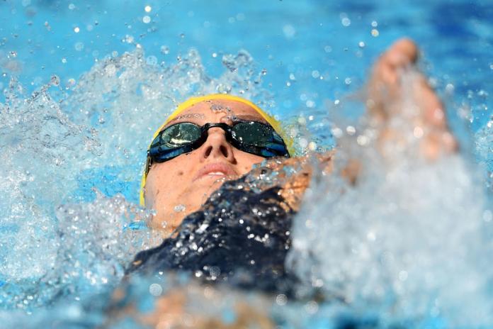 A closeup photo of a female Para swimmer competing in a backstroke race