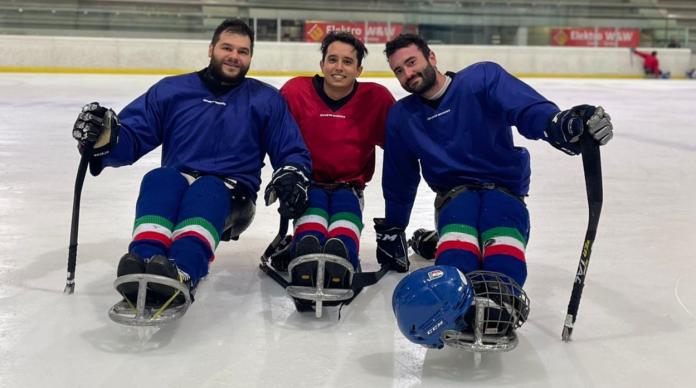 Three male Italian Para ice hockey athletes posing on the ice