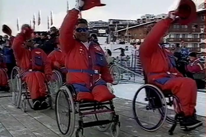 Four athletes in wheelchairs take part in a parade