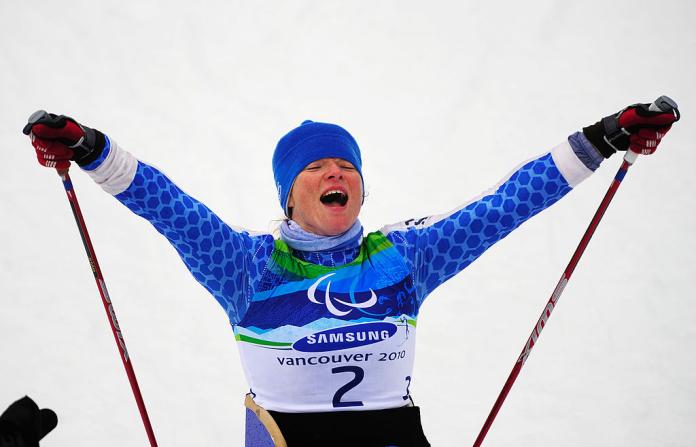 Francesca Porcellato raises her arms and celebrates winning gold at Vancouver 2010