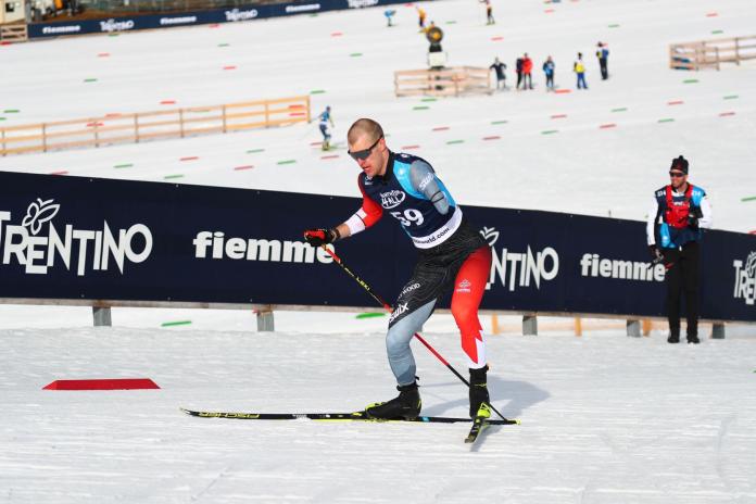 A male Para cross-country skiing athlete is in competition