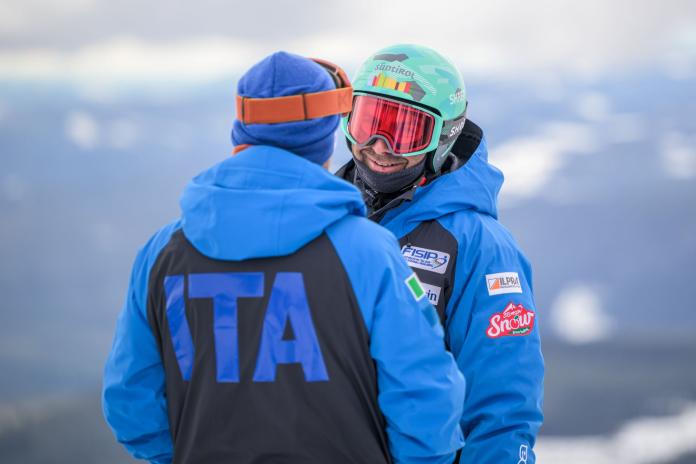 Para snowboarder Emanuel Perathoner is speaking with a person wearing a blue jacket that says Italy