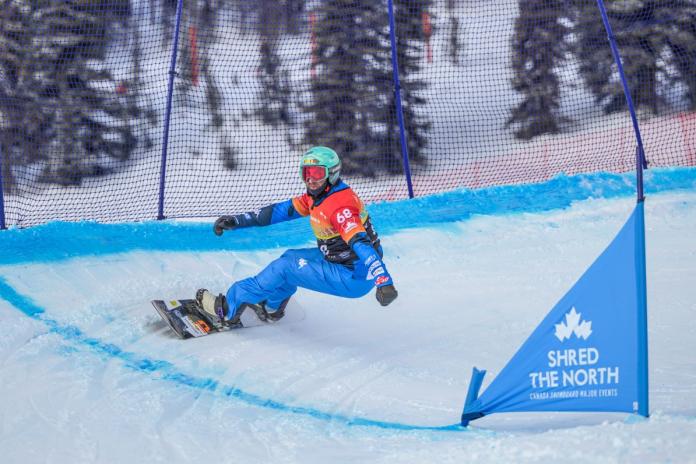 A male Para snowboard athlete is in competition.