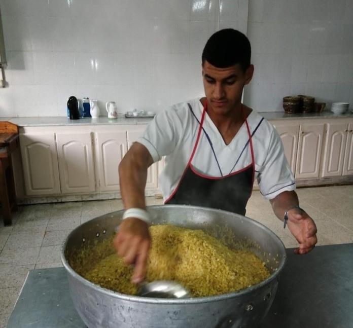 A male Para athlete is cooking a meal