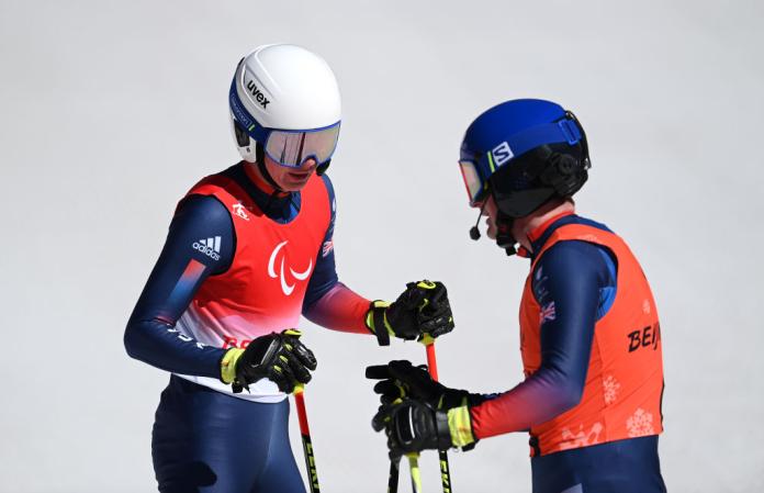 Two male Para alpine skiers are talking