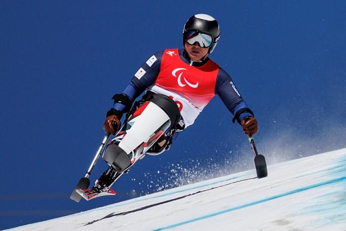 A male Para alpine skiing athlete is racing