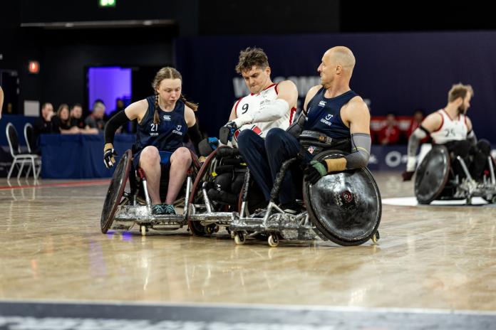 Three wheelchair rugby players in action