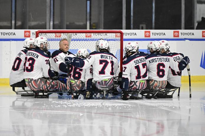 Norway's Para ice hockey team gather in front of a net