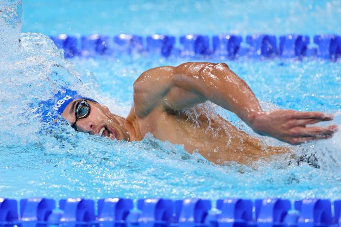 A male Para swimmer competing in a freestyle event