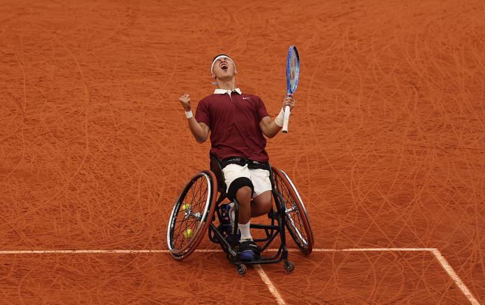 A male wheelchair tennis player makes a roar after winning the French Open final