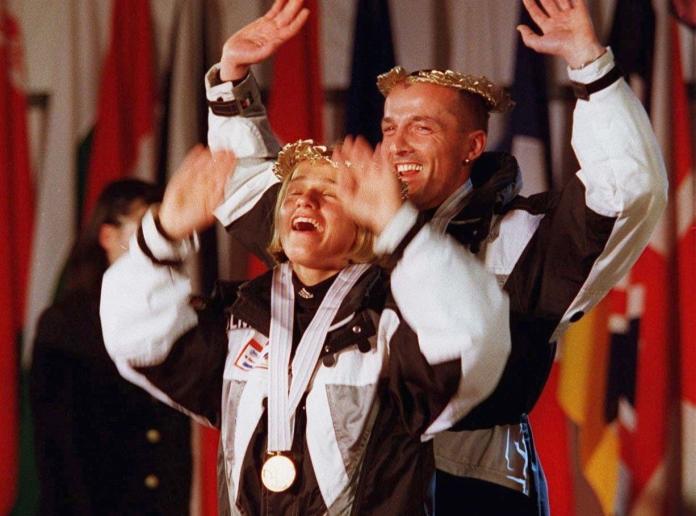 A female athlete reacts after receiving a medal at Nagano 1998, behind her is her sighted guide, a male skier
