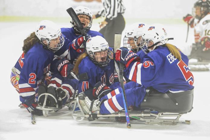 USA women's Para ice hockey team celebrating a goal on ice