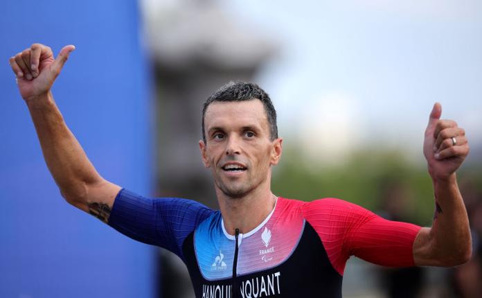 A male athlete raises both hands after finishing the finishline to celebrate a victory