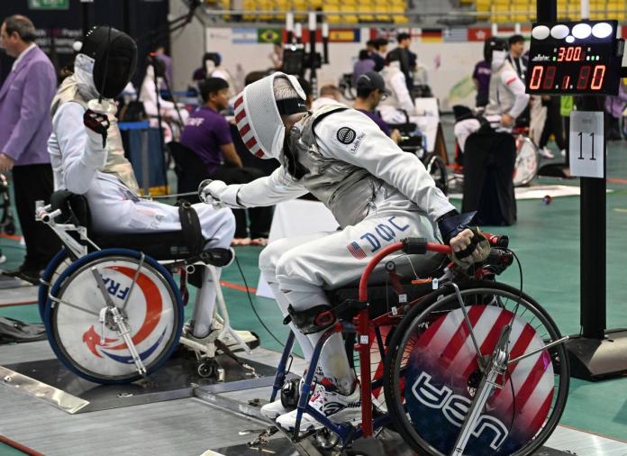 Two male wheelchair fencing athletes in competition